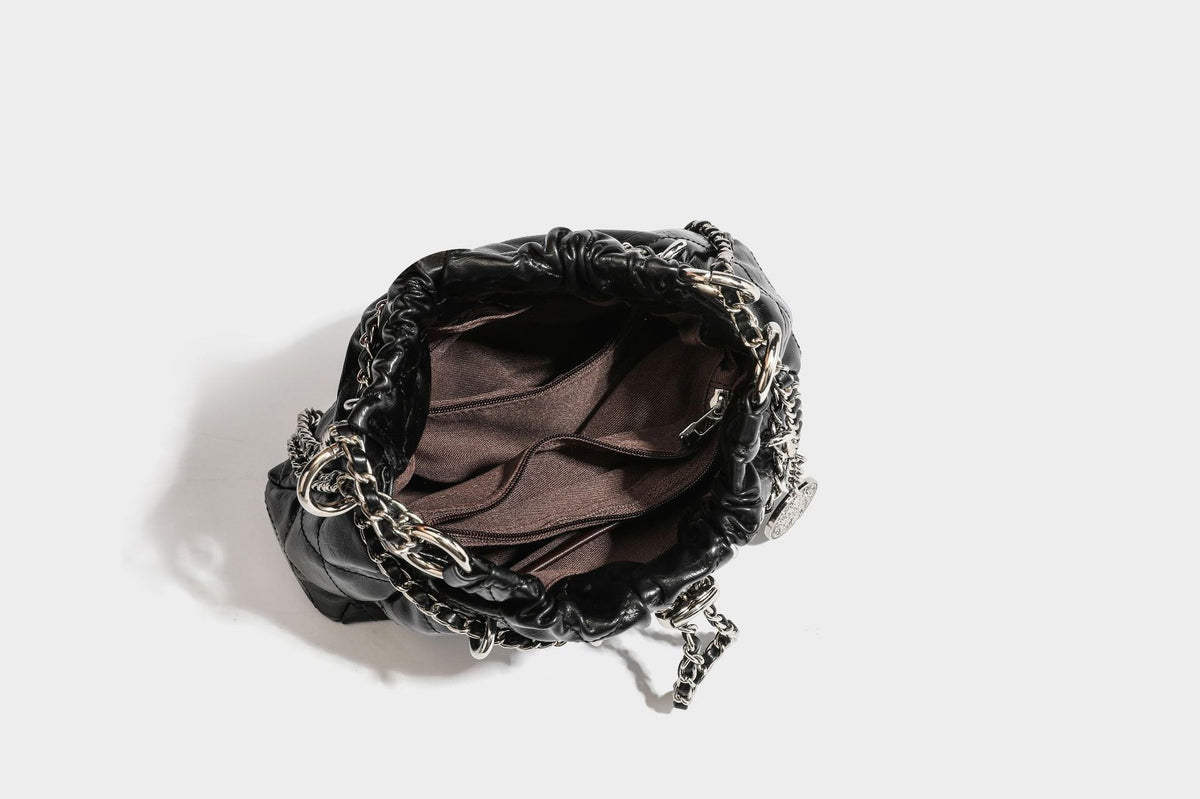 Glossy diamond-quilted drawstring bucket bag with silver chain shoulder strap and medallion charm, detail view 38