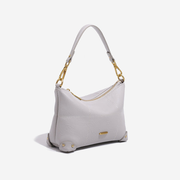 Small soft-structured shoulder bag with curved zip closure, stitched panel detailing, and gold-tone hardware, detail view 3