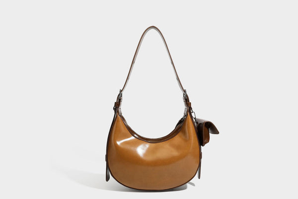 Glossy leather-look crescent hobo shoulder bag with dark contrast trim, silver-tone hardware, and attached mini flap pouch
