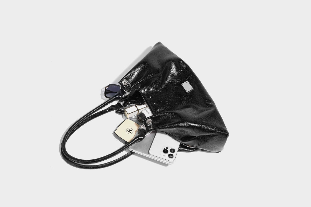 Locker fallende trapezförmige Tote-Schultertasche mit glänzender, geknautschter Lederoptik, zwei Schlaufenhenkeln, Reißverschluss oben und