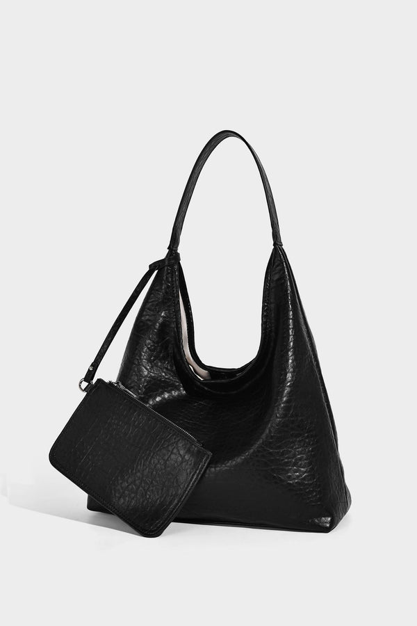 Slouchy hobo shoulder bag in pale yellow glossy pebbled leather-look finish with single shoulder strap and detachable front