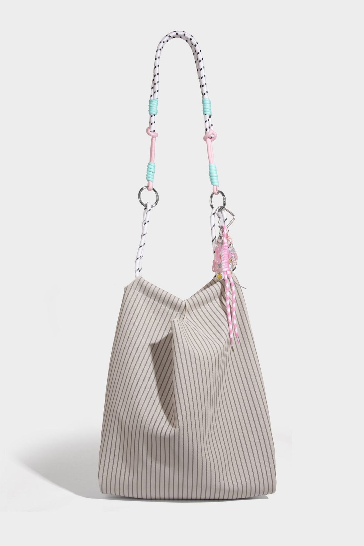 Slouchy pinstripe tote bag with braided rope handles, metal ring hardware, and colorful knotted rope charm, detail view 28