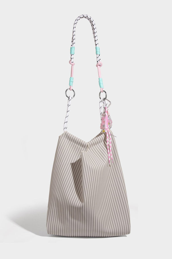 Slouchy pinstripe tote bag with braided rope handles, metal ring hardware, and colorful knotted rope charm, detail view 28