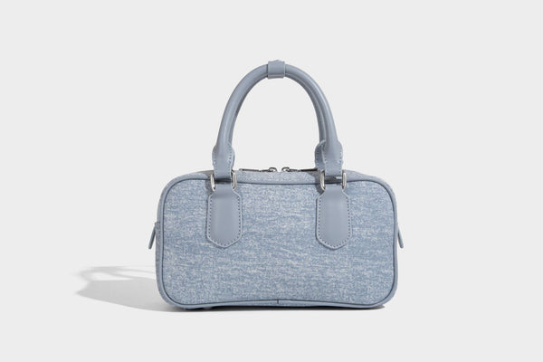 Small light blue denim-look barrel bag with white floral bead embroidery, dual top handles, and detachable shoulder strap