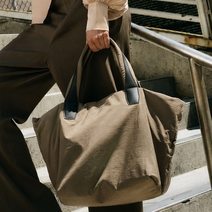 Large lightweight nylon tote bag with zipper closure, black leather-look handles, and trapezoid silhouette, detail view 3