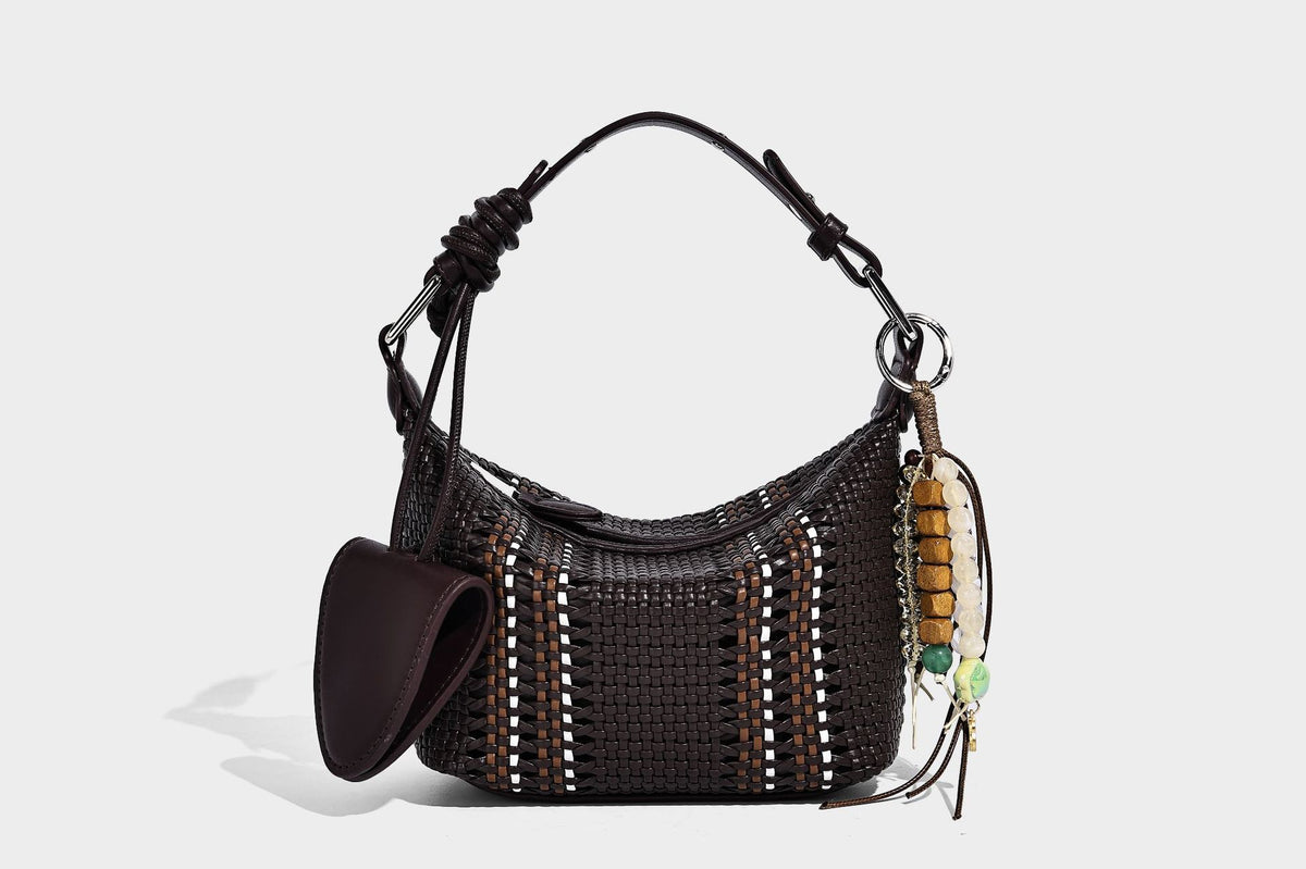 Small woven crescent shoulder bag with leather-look trim, zip closure, silver-tone ring hardware, and beaded tassel charm
