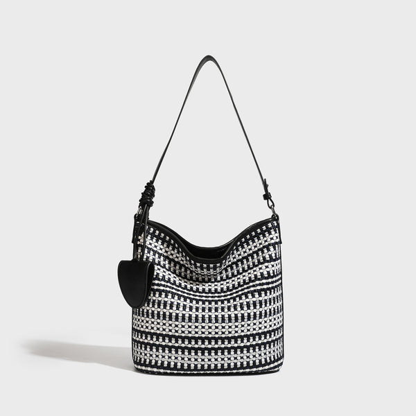 Woven stripe bucket shoulder bag in cream and dark brown with leather-look trim, knotted adjustable strap, and small shield