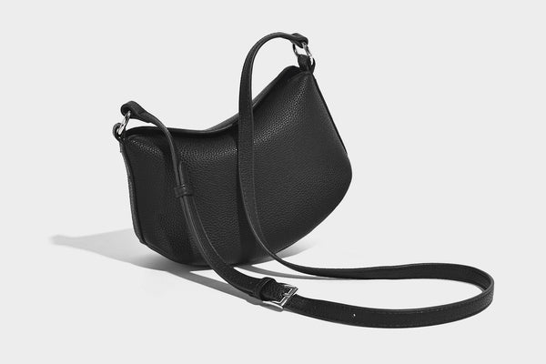 Small crescent half-moon bag in pebbled leather-look finish with braided top handle, silver-tone ring hardware, and, detail