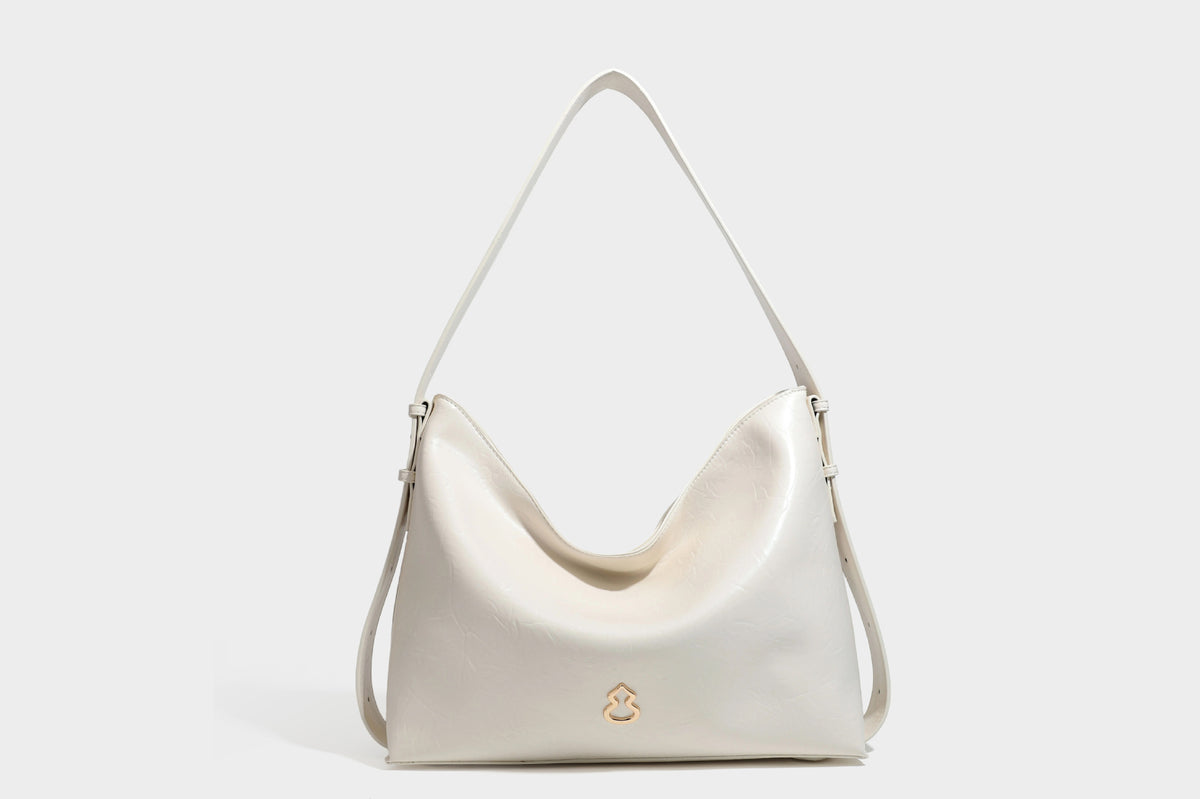 Lässig fallende Hobo-Schultertasche mit offenem Oberteil aus glänzender, karamellbrauner Lederoptik, mit Logo-Beschlägen in Goldoptik und langem, verstellbarem