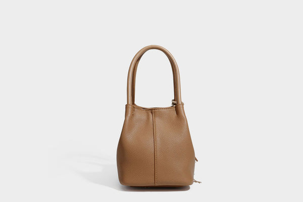 Pebbled leather-look bucket tote bag with rolled double handles, drawstring closure, braided cord charm, and detachable