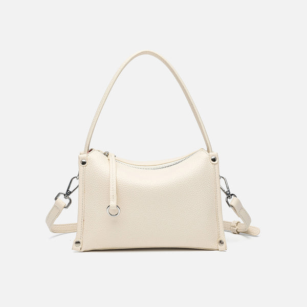 Small structured pebbled-finish convertible bag with silver corner studs, zip top, and detachable shoulder strap, front view