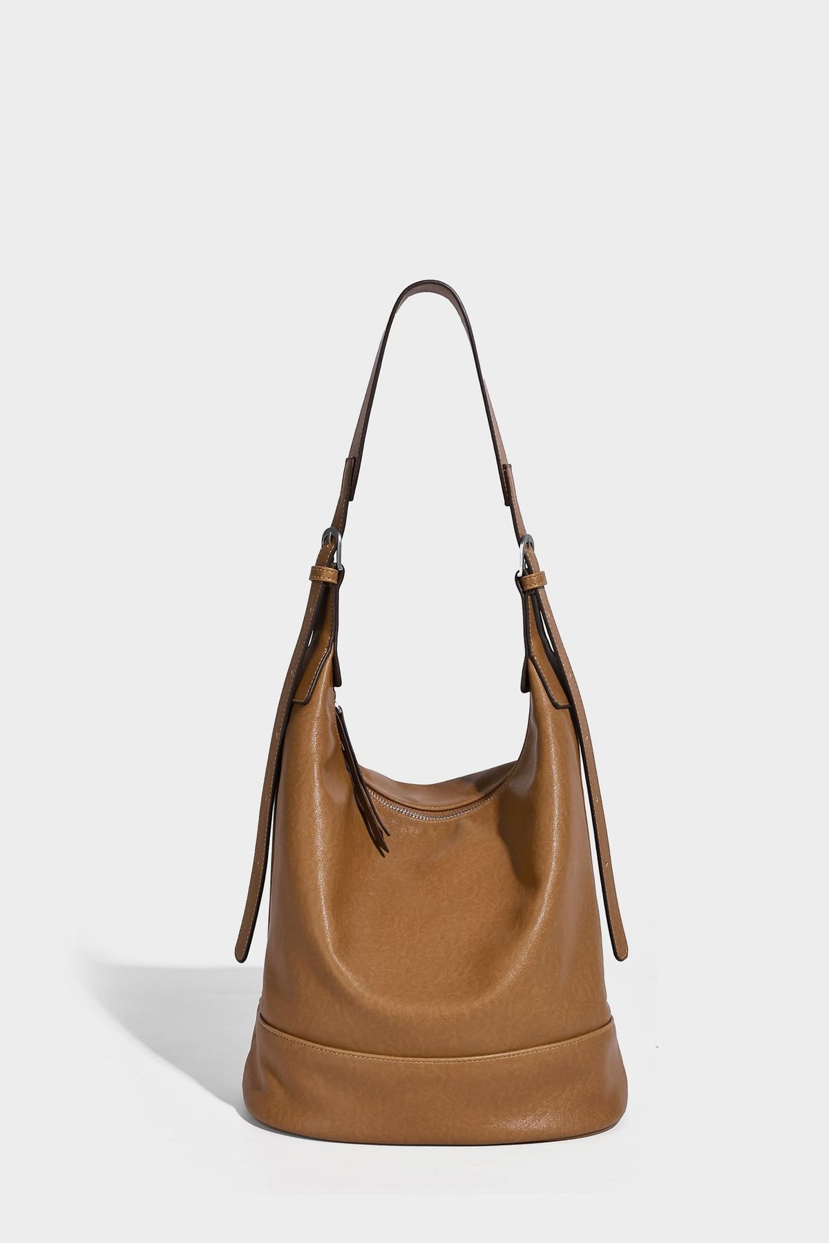 Slouchy bucket hobo shoulder bag in dark brown with glossy leather-look finish, top zip closure, and long adjustable, detail
