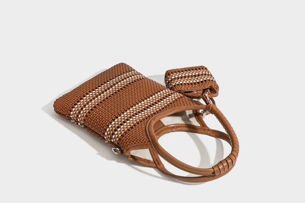 Color-block woven tote bag with rounded leather-look handles, detachable crossbody strap, and matching mini clip-on pouch in