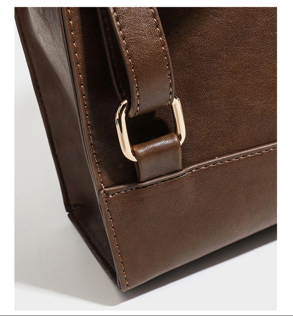 Structured suede-look convertible backpack handbag with flap closure and gold-tone emblem hardware in chocolate brown, detail