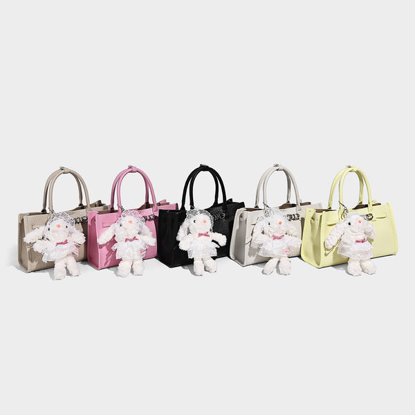 Structured trapezoid tote bag in pebbled leather-look finish with double top handles, silver-tone bar hardware, and, detail