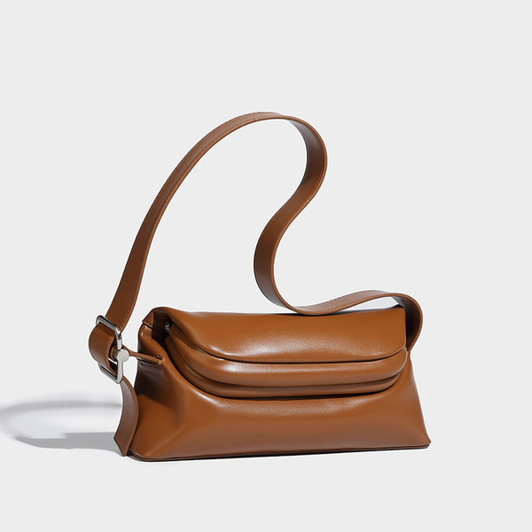 Compact structured baguette shoulder bag with smooth leather-look finish, zip top, and adjustable silver-buckle strap, detail