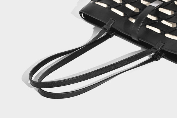 Structured woven lattice cutout tote bag with smooth leather-look trim, dual shoulder straps, and silver-tone hardware