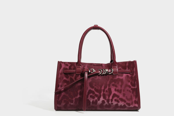 Structured leopard-print tote bag with glossy satin-like finish, dual rounded top handles, silver buckle-and-ring front