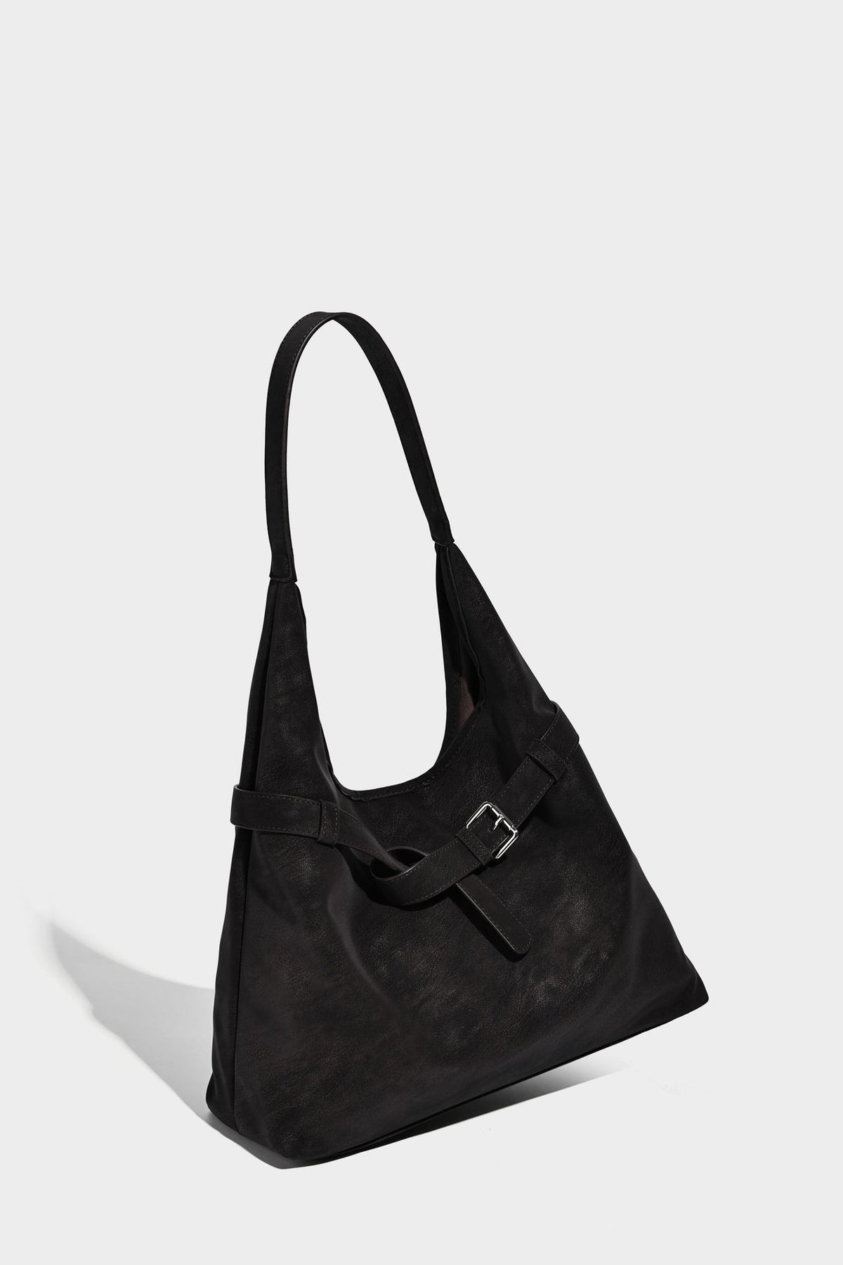 Slouchy oversized shoulder tote bag with matte textured finish, wrap-around buckle strap, and detachable front zip pouch