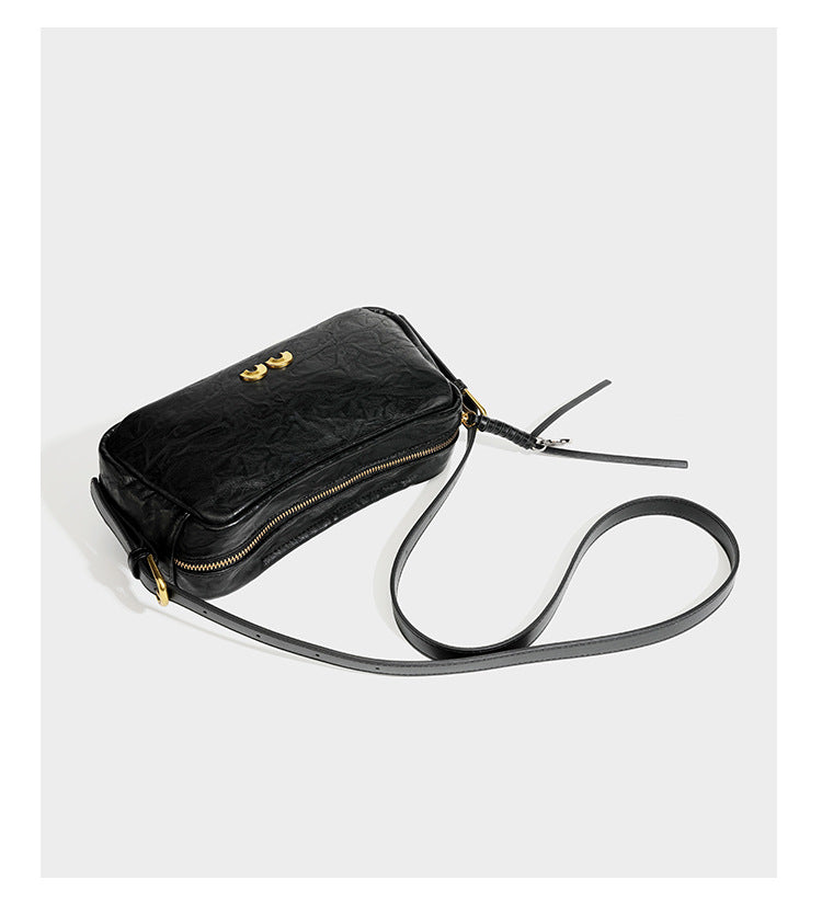 Compact black crinkled leather-look baguette shoulder bag with gold-tone arch hardware and adjustable strap, detail view 13