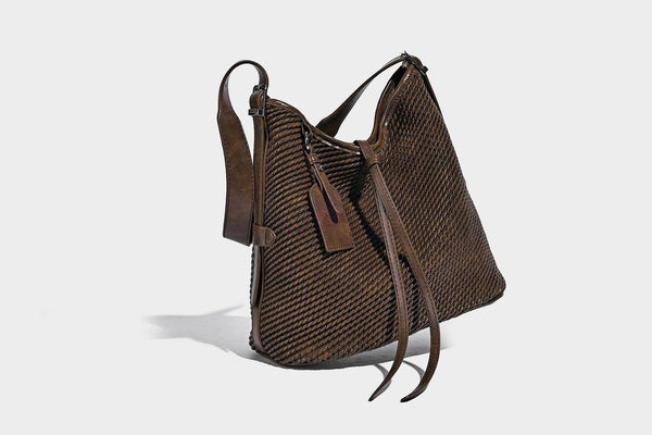 Große Schultertasche in Beutelform mit Flechtoptik, glatten Besätzen in Lederoptik, verstellbarem Riemen und hängendem Anhänger-Detail, Detailansicht