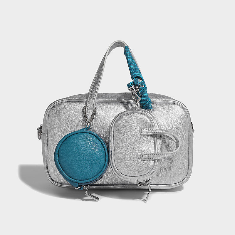 Structured pebbled leather-look Boston bowling bag in tan with blue detachable round mini pouch, dual top handles, and