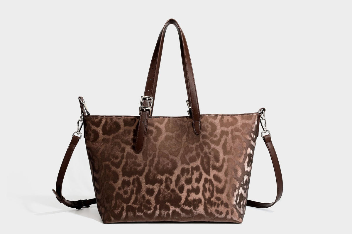 Glossy leopard-print tote bag with leather-look dark trim, dual top handles, detachable shoulder strap, and attached front