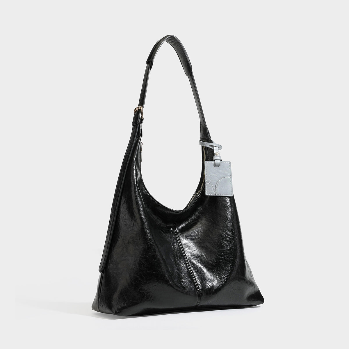 Große dunkelbraune, glänzende Hobo-Schultertasche mit Crinkle-Optik, Reißverschluss, goldfarbenen Metalldetails, verstellbarem Riemen und Hellblau
