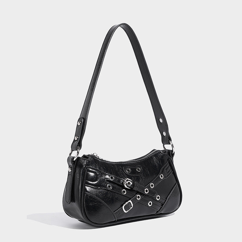 Compact moto-inspired shoulder bag with crisscross grommet strap detail, glossy textured finish, and adjustable crossbody