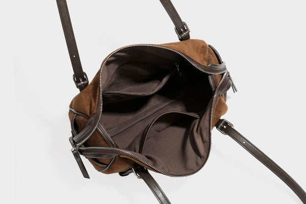 Large brown suede-finish barrel shoulder bag with dark leather-look trim, silver-tone zippers, dual top handles, and long