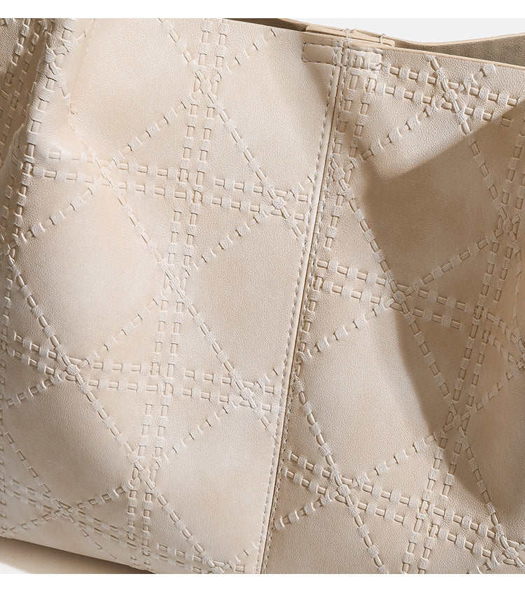 Large open-top tote bag with raised diamond-lattice stitching, long double shoulder handles, and gold-tone magnetic snap