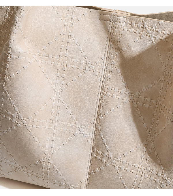 Large open-top tote bag with raised diamond-lattice stitching, long double shoulder handles, and gold-tone magnetic snap