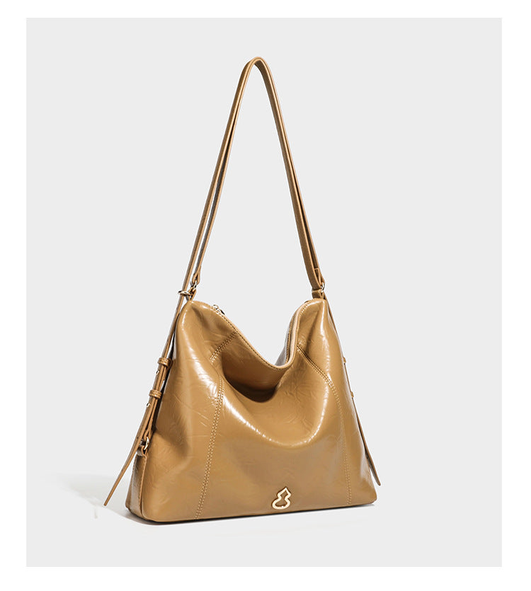 Große, lässig fallende Hobo-Schultertasche in glänzender, geknautschter Lederoptik mit goldfarbenen Beschlägen und langem, verstellbarem Riemen