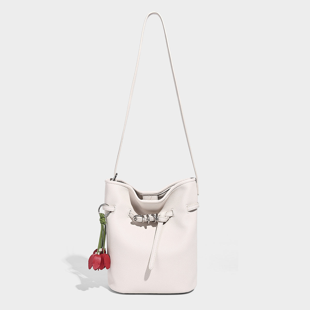 Small pebbled leather-look bucket bag with front drawstring toggle hardware and long adjustable shoulder strap, detail view 3