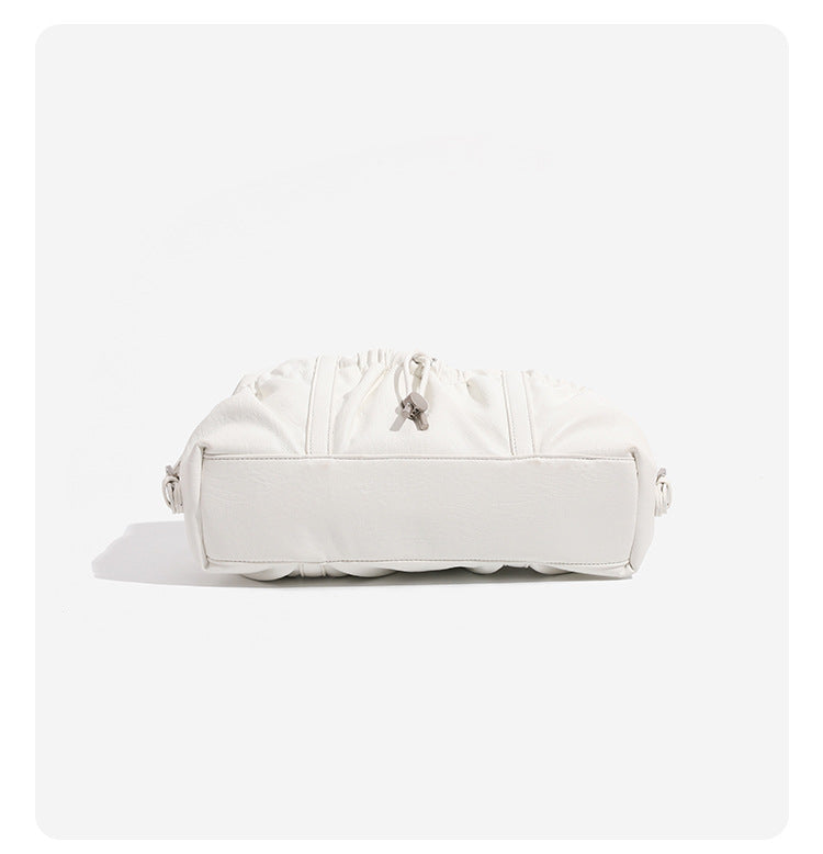Ivory leather-look shoulder bag with ruched front panels, drawstring toggle, silver-tone hardware, and dual top handles