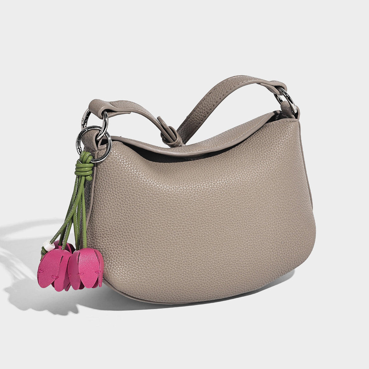 Small crescent half-moon bag in pebbled leather-look finish with braided top handle, silver-tone ring hardware, and, detail