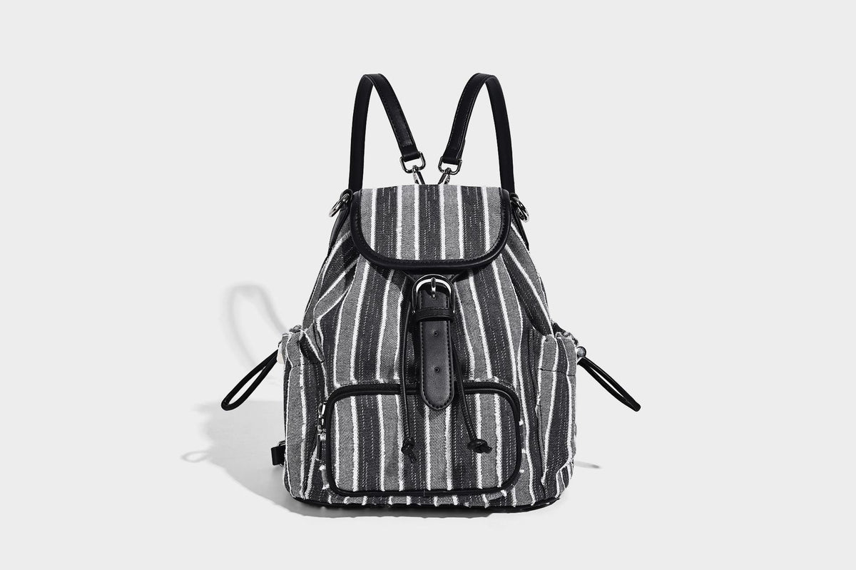 Weicher Rucksack aus gewebtem Material mit vertikalen Streifen, Überschlag, Kordelzug, vorderer Reißverschlusstasche, weißen Besätzen und Trägern in Lederoptik, Detailansicht