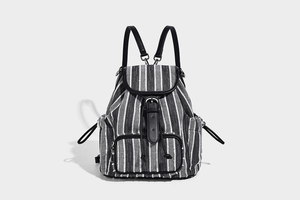Weicher Rucksack aus gewebtem Material mit vertikalen Streifen, Überschlag, Kordelzug, vorderer Reißverschlusstasche, weißen Besätzen und Trägern in Lederoptik, Detailansicht