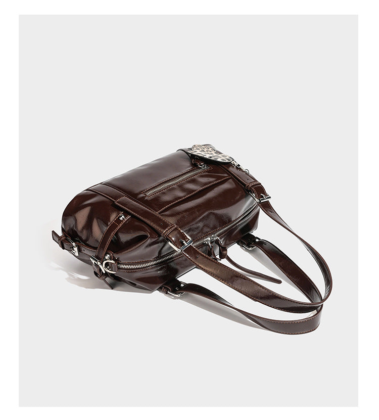 Strukturierte Schultertasche aus glänzendem Lederimitat mit abgerundetem Korpus, silberfarbenen Metalldetails, Reißverschlussfach vorne und Leopardenmuster
