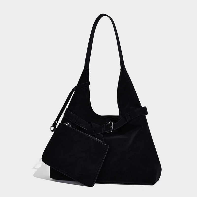 Slouchy oversized shoulder tote bag with matte textured finish, wrap-around buckle strap, and detachable front zip pouch