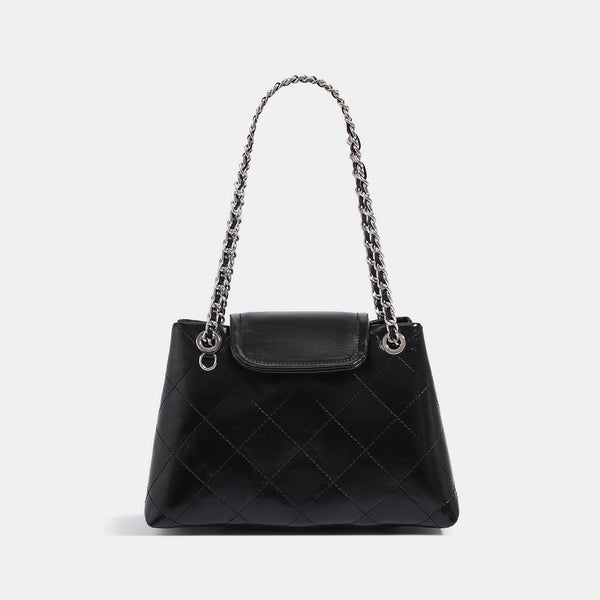 Quilted trapezoid shoulder bag with chain straps, flap closure, and ring hardware, detail view 6