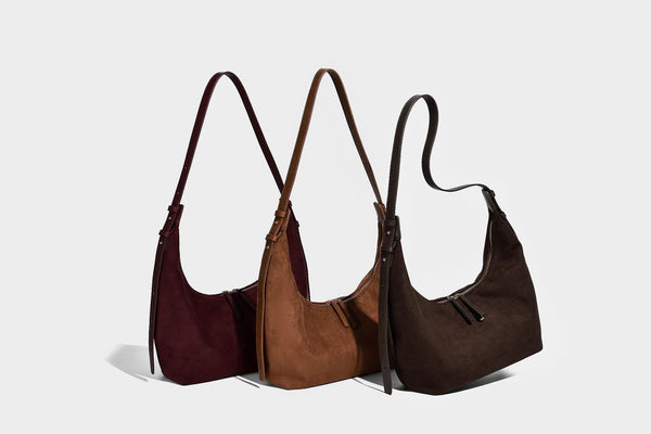 Slouchy crescent hobo shoulder bag in dark chocolate matte suede-look finish with adjustable strap and twin-pull top zip