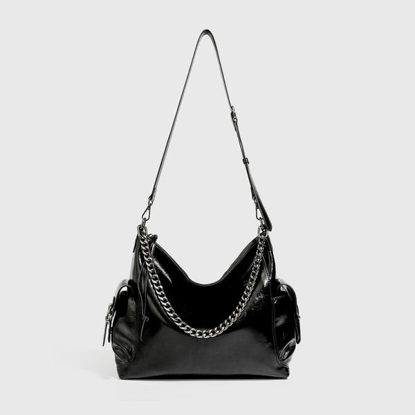 Slouchy hobo shoulder bag with glossy leather-look finish, silver-tone chain drape across front, side buckle pockets, and