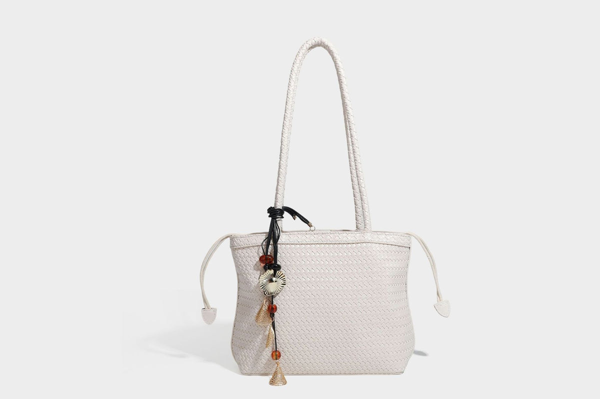 Structured woven leather-look tote bag in dark brown with long shoulder straps, side drawstring ties, and gold filigree