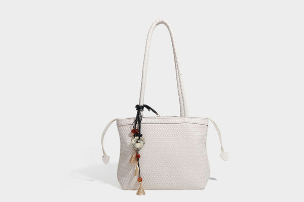 Structured woven leather-look tote bag in dark brown with long shoulder straps, side drawstring ties, and gold filigree