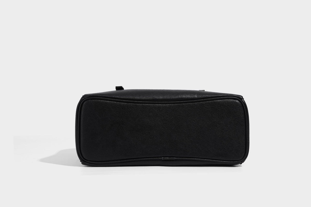 Structured dome-shaped shoulder bag with leather-look finish, top zipper closure, dual adjustable slim straps, and, detail