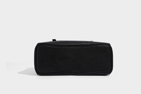 Structured dome-shaped shoulder bag with leather-look finish, top zipper closure, dual adjustable slim straps, and, detail