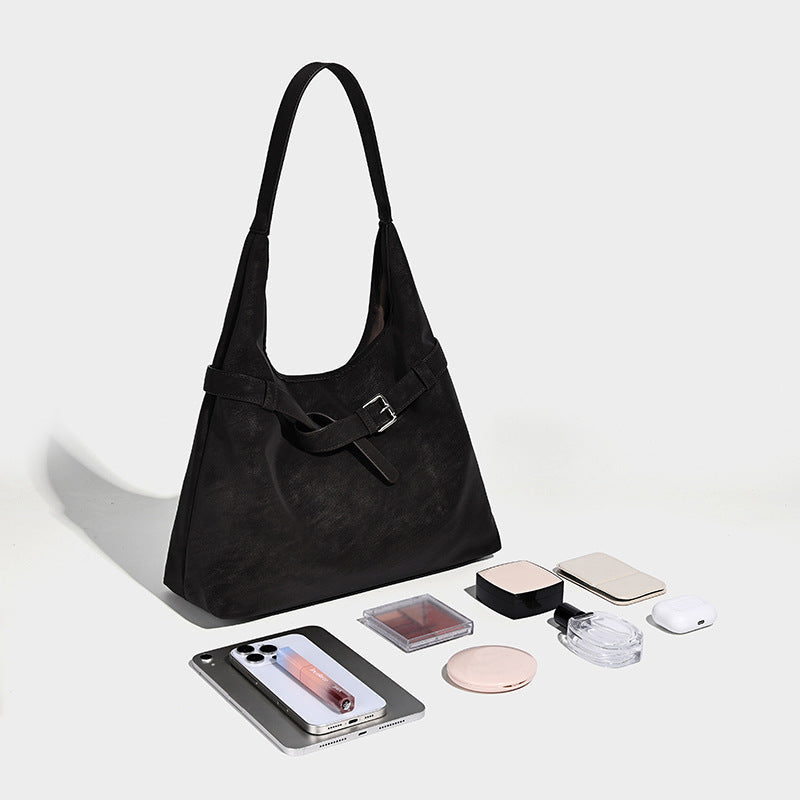 Slouchy oversized shoulder tote bag with matte textured finish, wrap-around buckle strap, and detachable front zip pouch