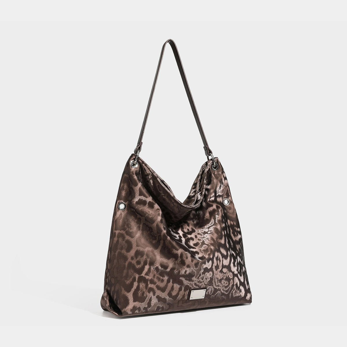 Slouchy leopard-print hobo shoulder bag with glossy satin-like finish, silver-tone ring hardware, and slim shoulder strap