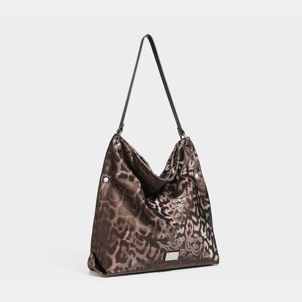 Lässig fallende Hobo-Schultertasche mit Leopardenprint, glänzender satinähnlicher Oberfläche, silberfarbenen Ringbeschlägen und schmalem Schulterriemen